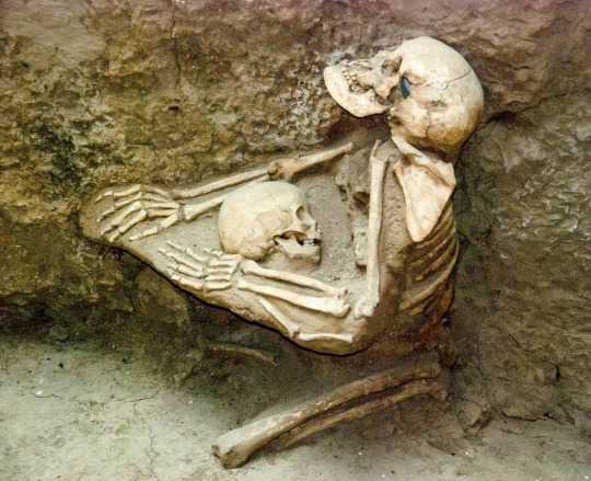 Two skeletons, a woman clutching a child to her breast, preserved in a mudflow in Tibet for 4000 years. Photo by Jane Qiu.