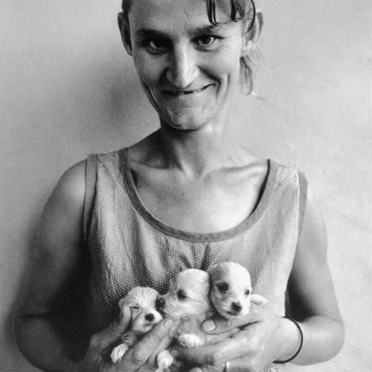 Roger Ballen Wife-of-abattoir-worker-holding-three-puppies-Orange-Free-State-1994